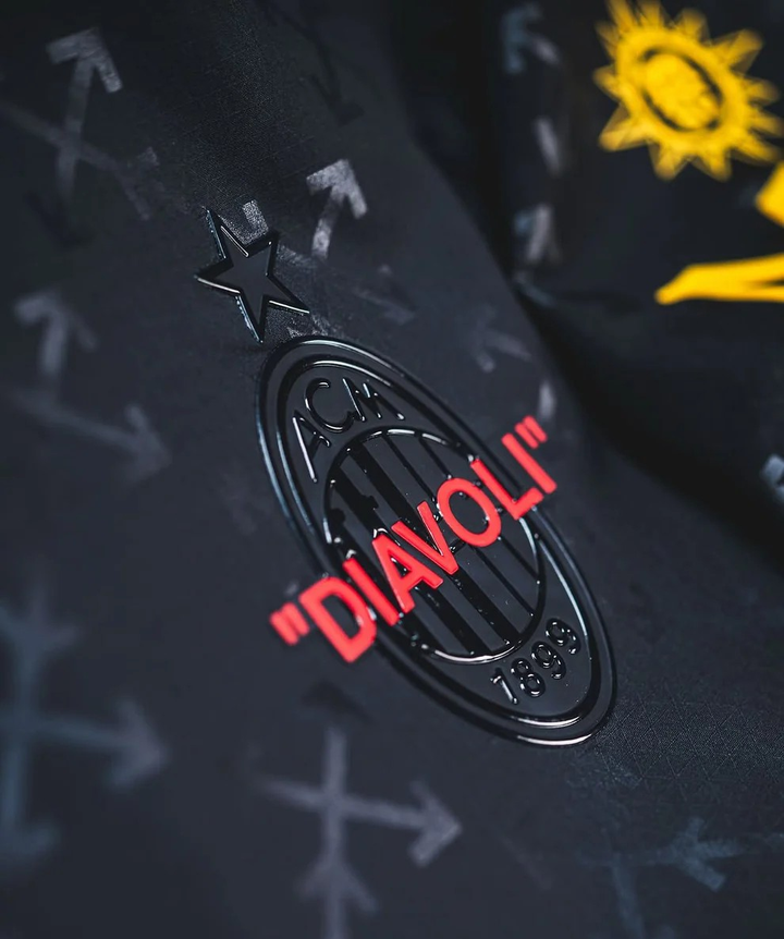 Close-up of AC Milan Off White Jersey 2024 with emblem featuring the 'Diavoli' logo