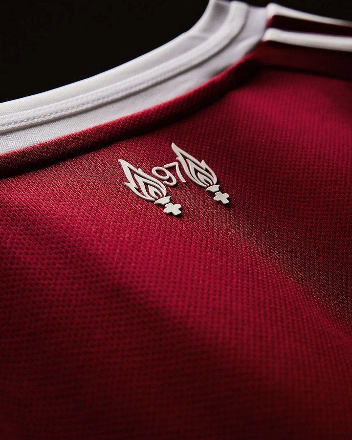 The Dribble Store close up of Liverpool home jersey 2025-26 full sleeves red textured fabric white collar emblem