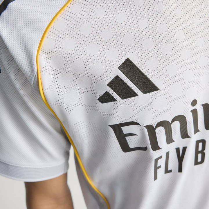 Close up of Real Madrid 2025 home jersey chest showing Adidas logo white fabric and yellow piping from The Dribble Store
