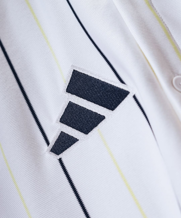 The Dribble Store Real Madrid special edition jersey 2025-26 close up of white pinstripe fabric with embroidered black three bar logo