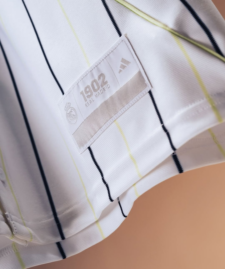 The Dribble Store close up of Real Madrid special edition jersey 2025-26 white pinstripe fabric showing 1902 tag and Adidas logo