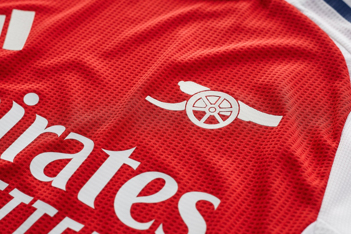 Close-up of Arsenal home jersey 2024 player version featuring club logo and breathable fabric design