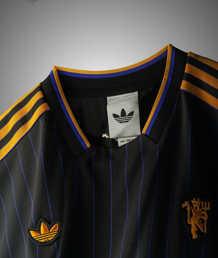 The Dribble Store Manchester United Terrace Icon jersey 2025-26 featuring black and gold design with classic stripes