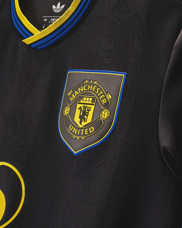 Close-up of Manchester United third jersey 2025-26 featuring the official club crest in vibrant colors
