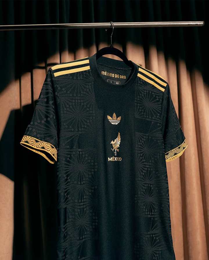 Mexico de Oro 2025-26 Black jersey with gold accents and distinctive patterns hanging on a rack